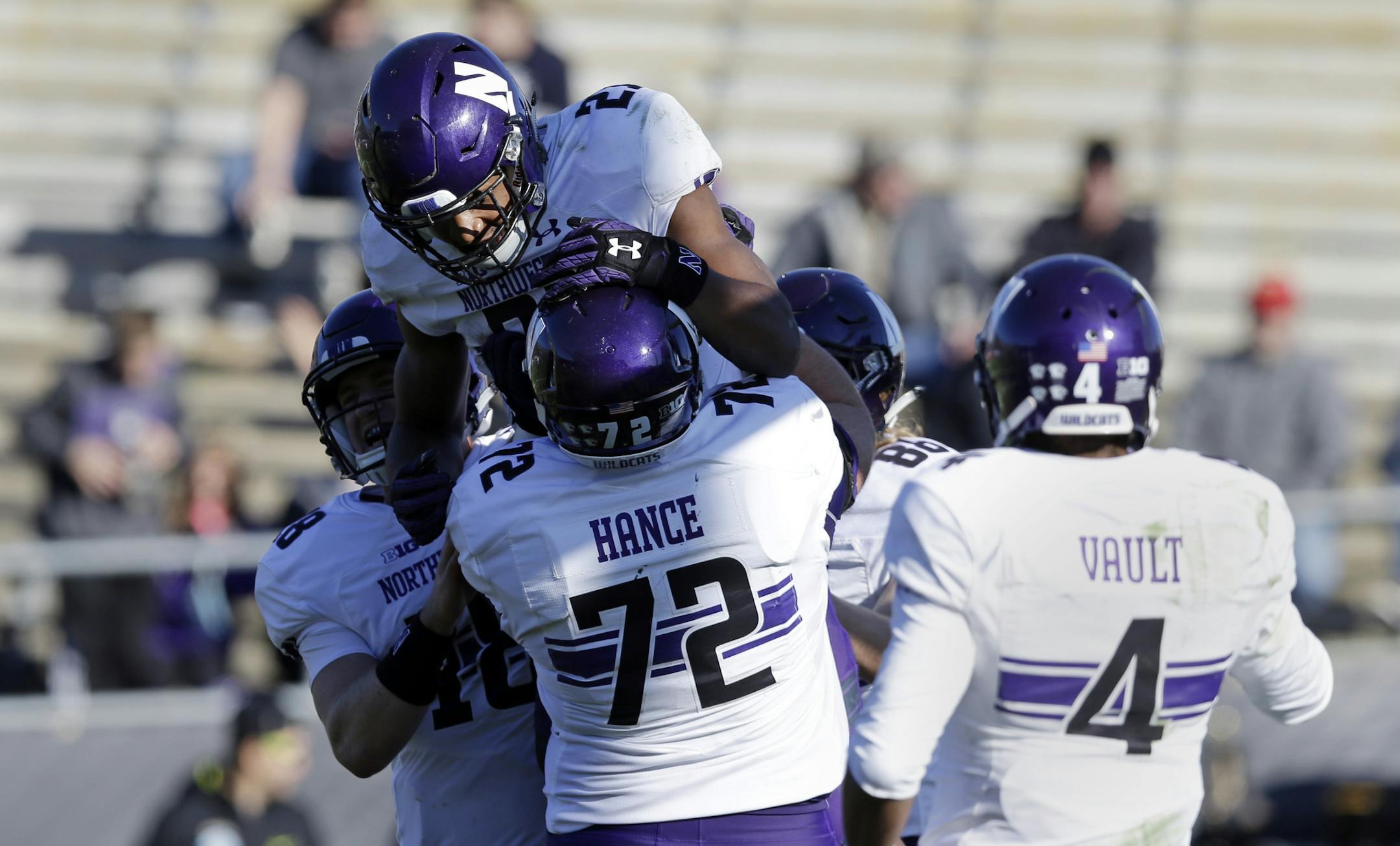Northwestern running back Justin Jackson (21) celebrates a touchdown with teammates quarterback Clayton Thorson (18) left, and offensive lineman Blake Hance (72) during the second half of an NCAA college football game against Purdue in West Lafayette, Ind., Saturday, Nov. 12, 2016. against Northwestern defeated Purdue. (AP Photo/Michael Conroy)