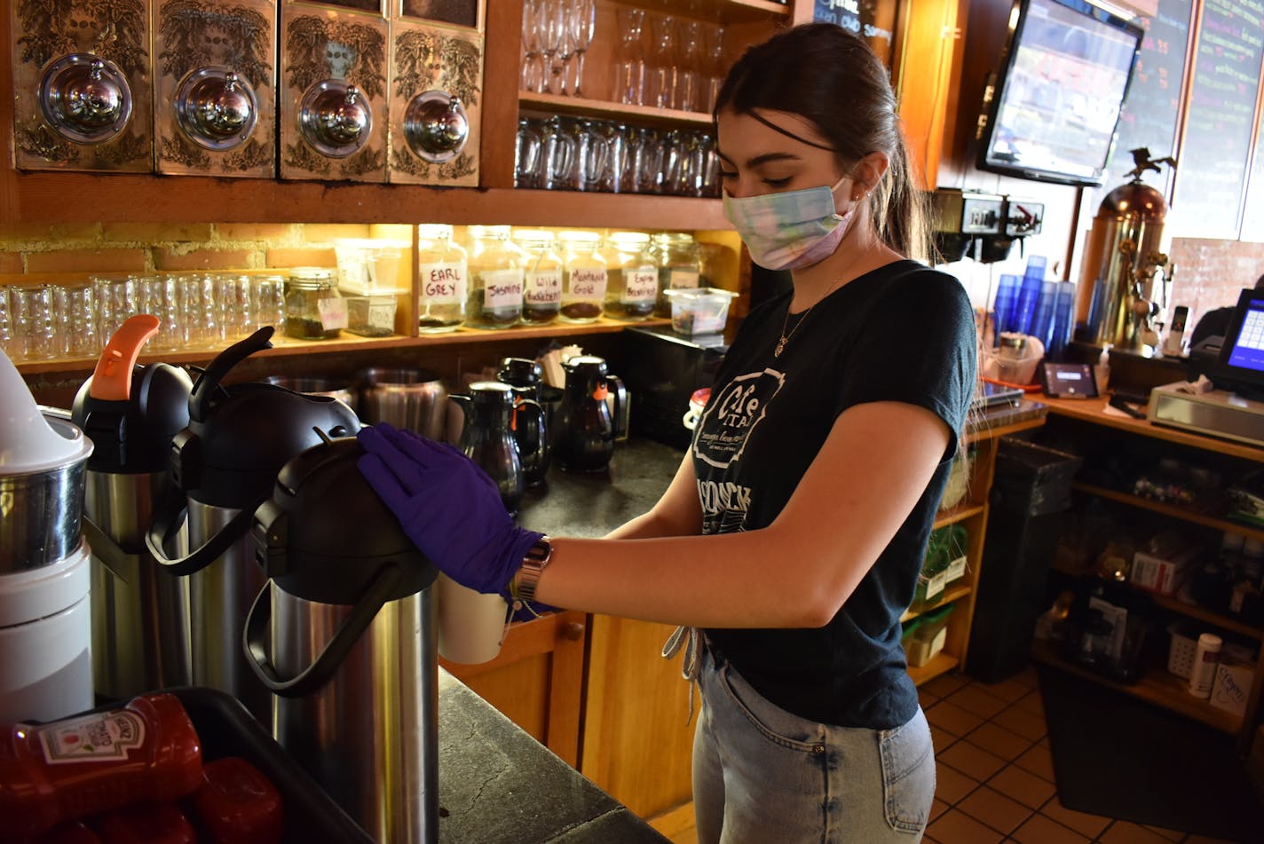 Server Jane Goodridge fills a coffee for a customer at the McCormick Cafe on Monday May 4, 2020 in Billings, Mont. Restaurants, bars, brewpubs and casinos were able to reopen Monday with restrictions as the state lifted closure orders imposed over the coronavirus. (AP Photo/Matthew Brown)