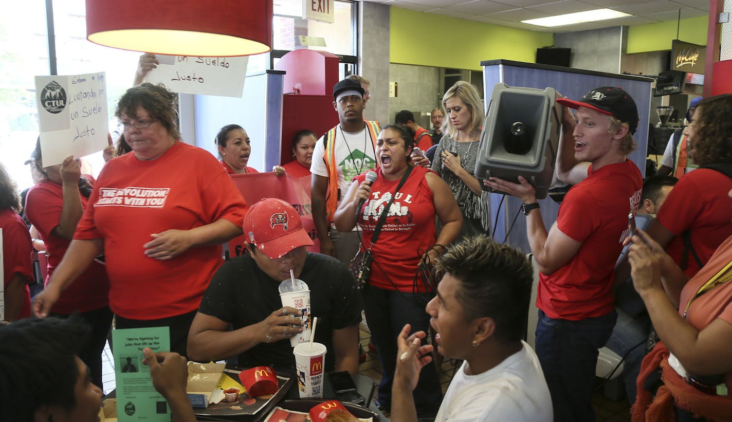 Food workers protested low wages and some struck to demand $15 an hour wages at the Uptown McDonalds Thursday, Sept. 4, 2014, in Minneapolis, MN. Here, Veronica Mendez Moore, center, with microphone, spoke by microphone to protestors inside the Uptown McDonalds .](DAVID JOLES/STARTRIBUNE)djoles@startribune.com Food workers protested low wages and some struck to demand $15 an hour wages at the Uptown McDonalds Thursday, Sept. 4, 2014. Some cities in America have implemented a $15 minimum wage.