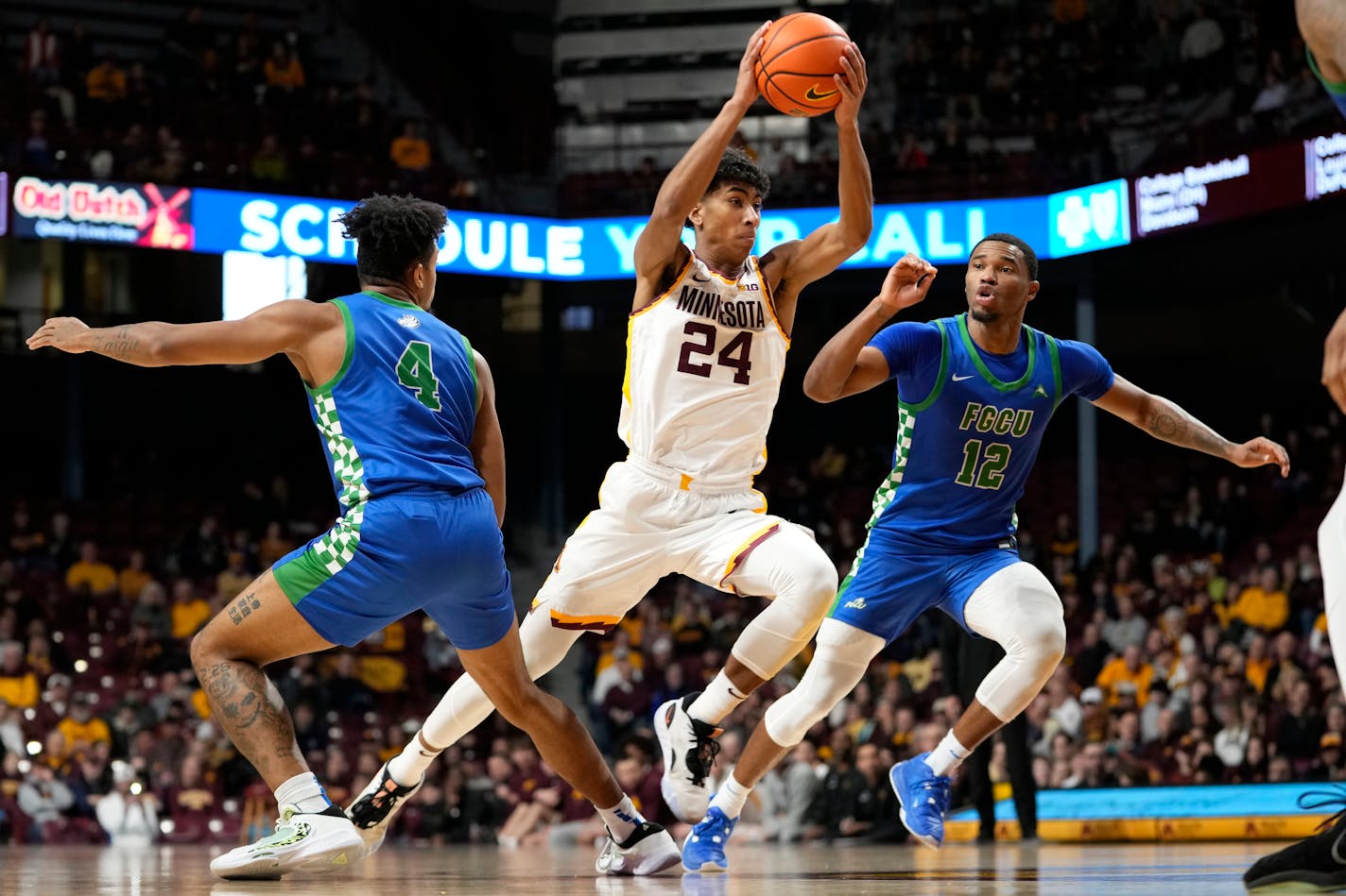 Gophers guard Cam Christie works toward the basket as Florida Gulf Coast guards Cyrus Largie (4) and Franco Miller Jr. (12) defend during the first half Saturday