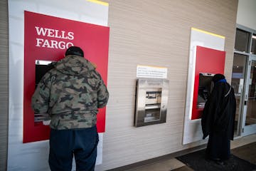 Customers use the Wells Fargo ATMs inside the lobby at a branch in Minneapolis on Thursday.