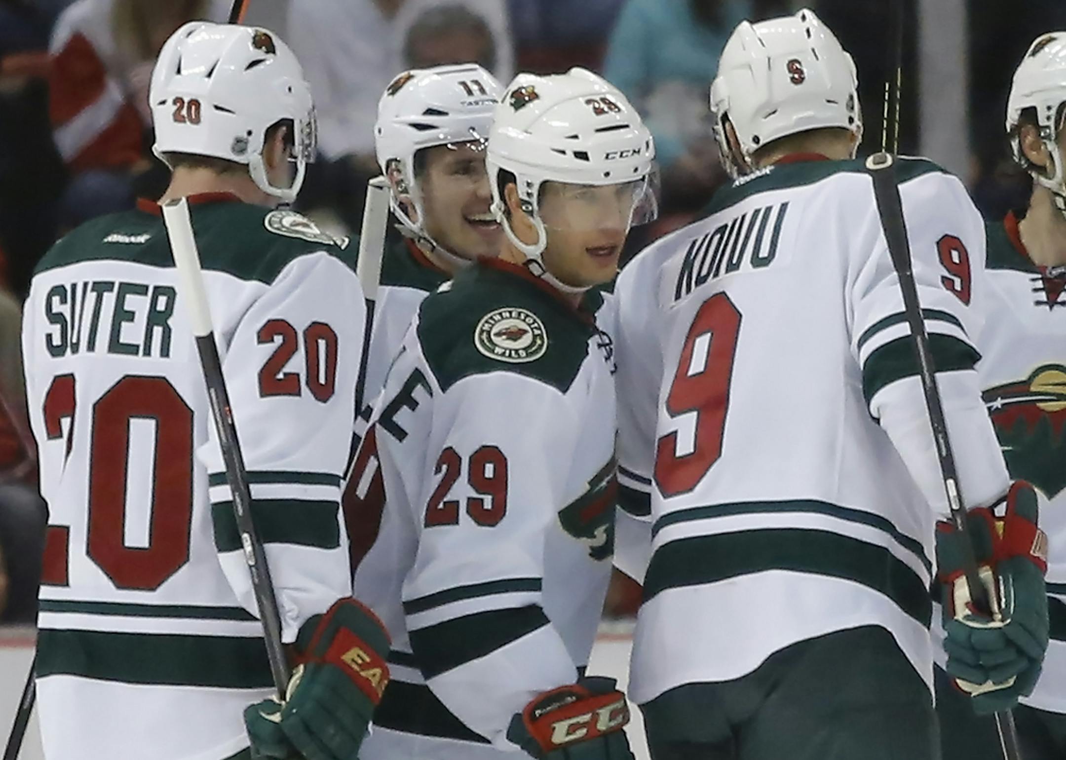 Minnesota Wilds' Jason Pominville (29) celebrates his goal with teammates Ryan Suter (20), Mikko Koivu (9), of Finland, and Zach Parise (11) during the second period of an NHL hockey game against the Detroit Red Wings Sunday, March 23, 2014 in Detroit. (AP Photo/Duane Burleson)