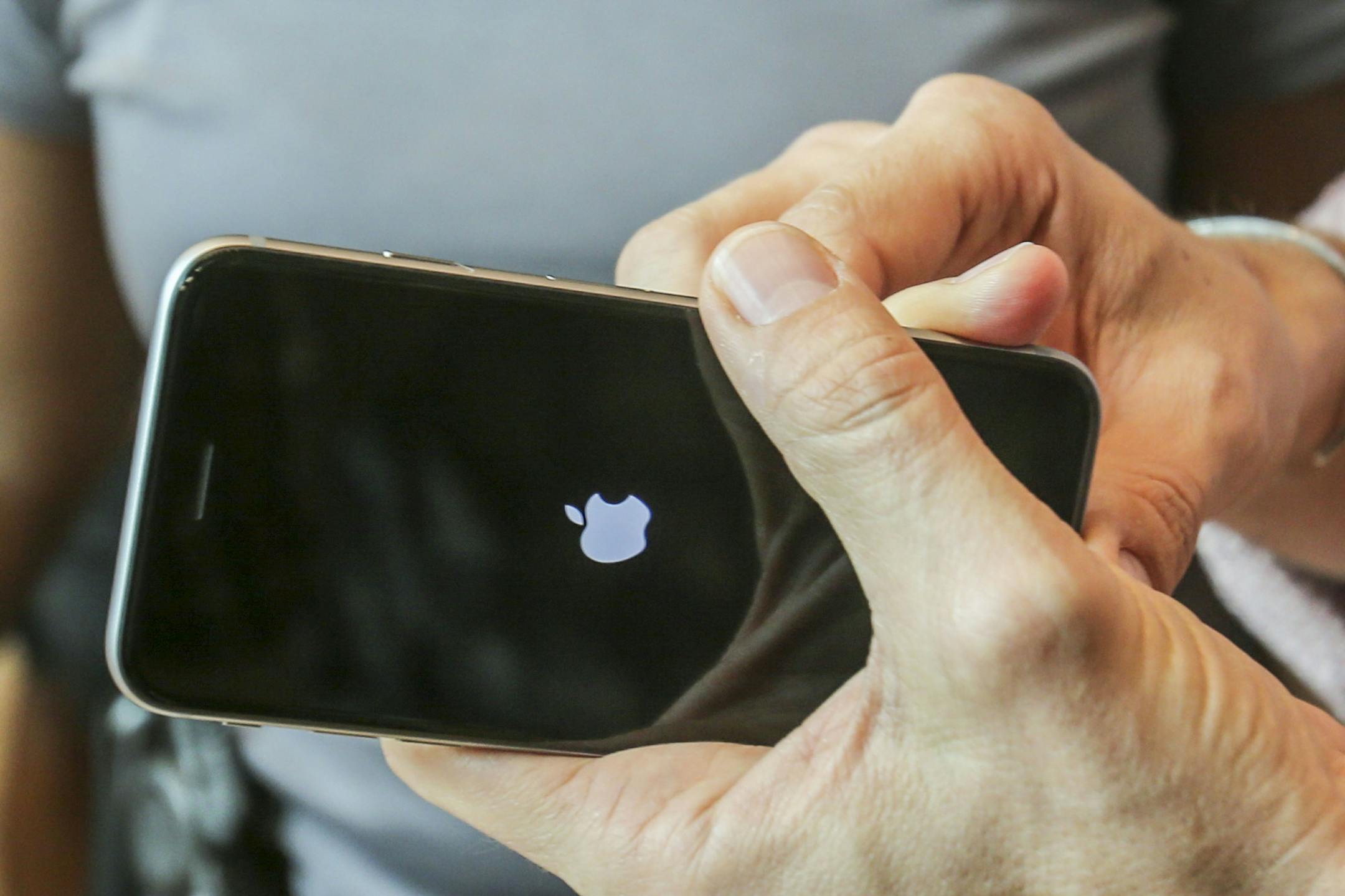 FILE - In this Sept. 25, 2015 file photo, a customer tries out his Apple iPhone 6s smartphone at the Apple store at The Grove in Los Angeles. Apple reports quarterly financial results on Tuesday, Oct. 27, 2015. (AP Photo/Ringo H.W. Chiu, File)