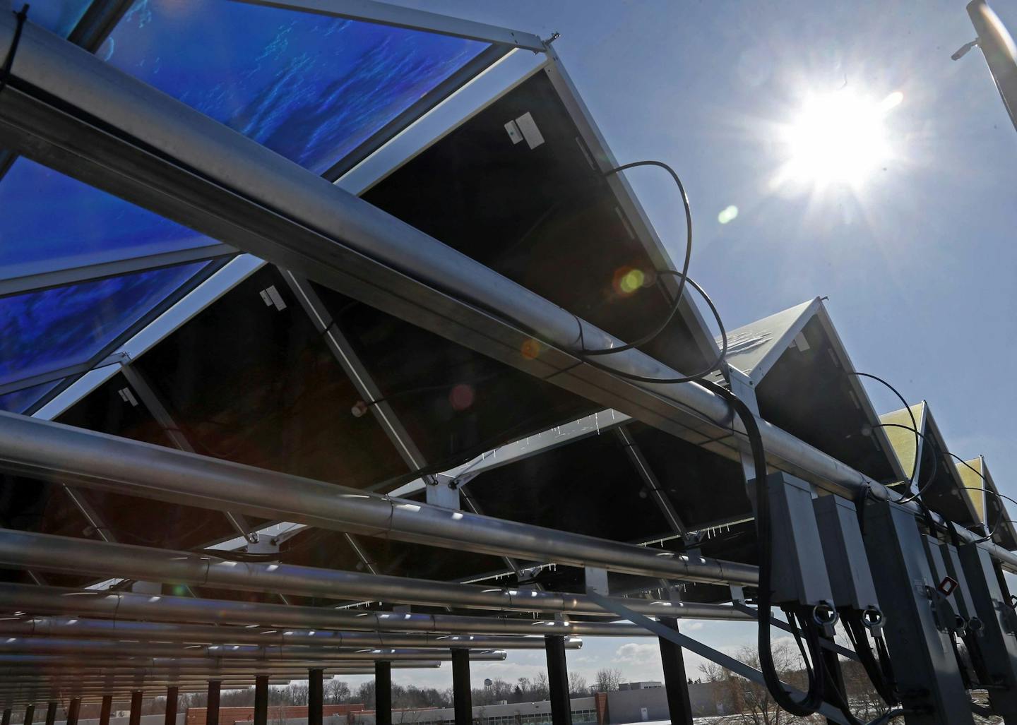 In this Feb. 26, 2015 photo, the sun shines down on solar panels that are part of the Wright-Hennepin Cooperative Electric Association's community gardens are shown in Rockford, Minn. Community solar gardens are a new concept in renewable energy, allowing customers who cannot put up solar panels to buy into the green energy boom anyway. (AP Photo/Jim Mone) ORG XMIT: MP102