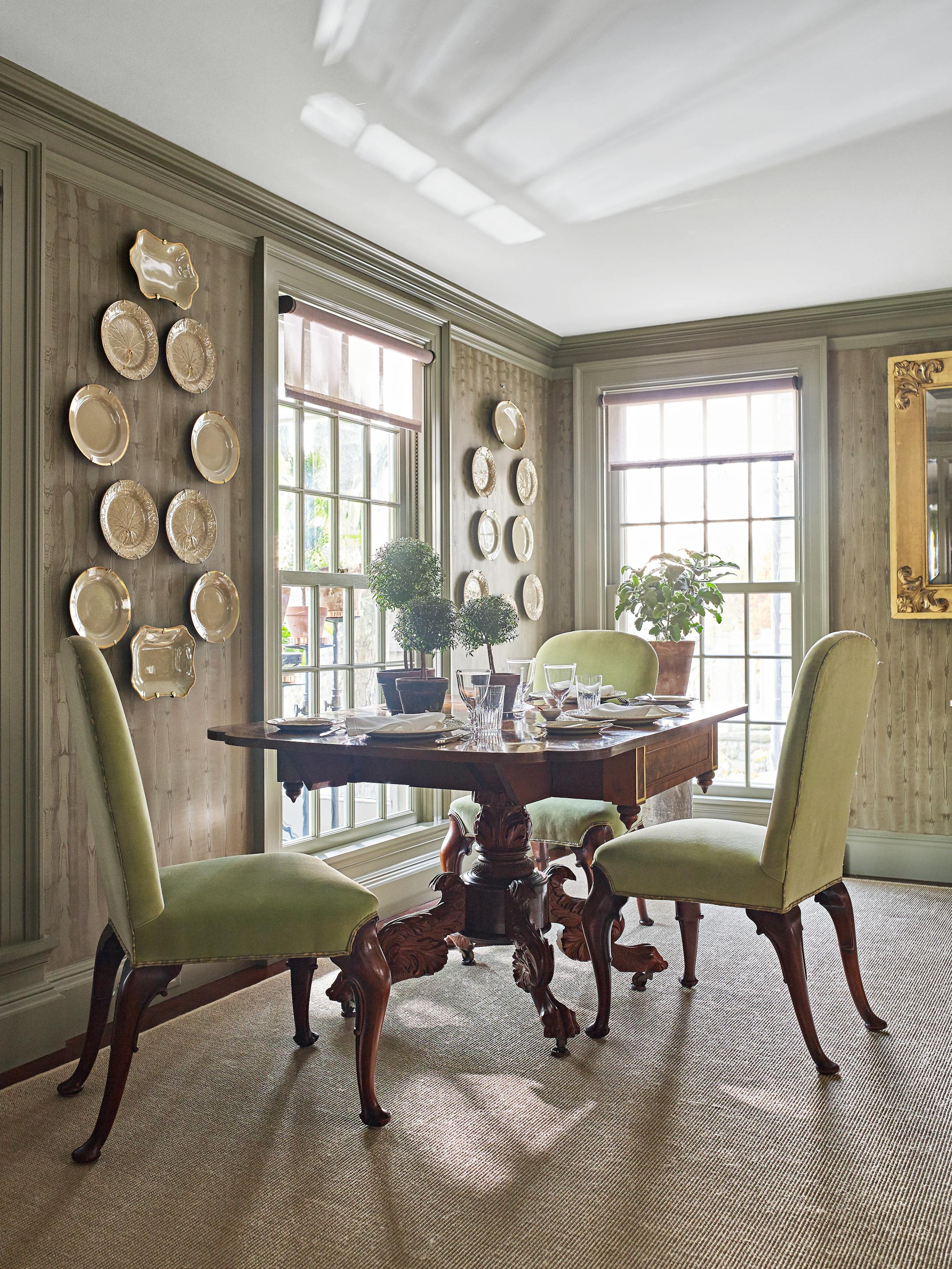 BC-ASK-MARTHA-BEDFORD-INTERIORS-ART-NYTSF — An American Federal dining table, topped with myrtle topiaries and a potted fuzzy-leafed kalanchoe, sits under some of Martha's Wedgwood drabware collection. "The plates fill the small slices of wall perfectly," says Kevin Sharkey. The chairs are from a set that Martha uses all over Bedford. She also had new sisal carpets laid on the main floor. "I never wear shoes in my house, and I love walking on that rug," she says. (Pieter Estersohn/Martha Stewart Living Online) — ONLY FOR USE WITH ARTICLE SLUGGED — BC-ASK-MARTHA-BEDFORD-INTERIORS-ART-NYTSF — OTHER USE PROHIBITED.