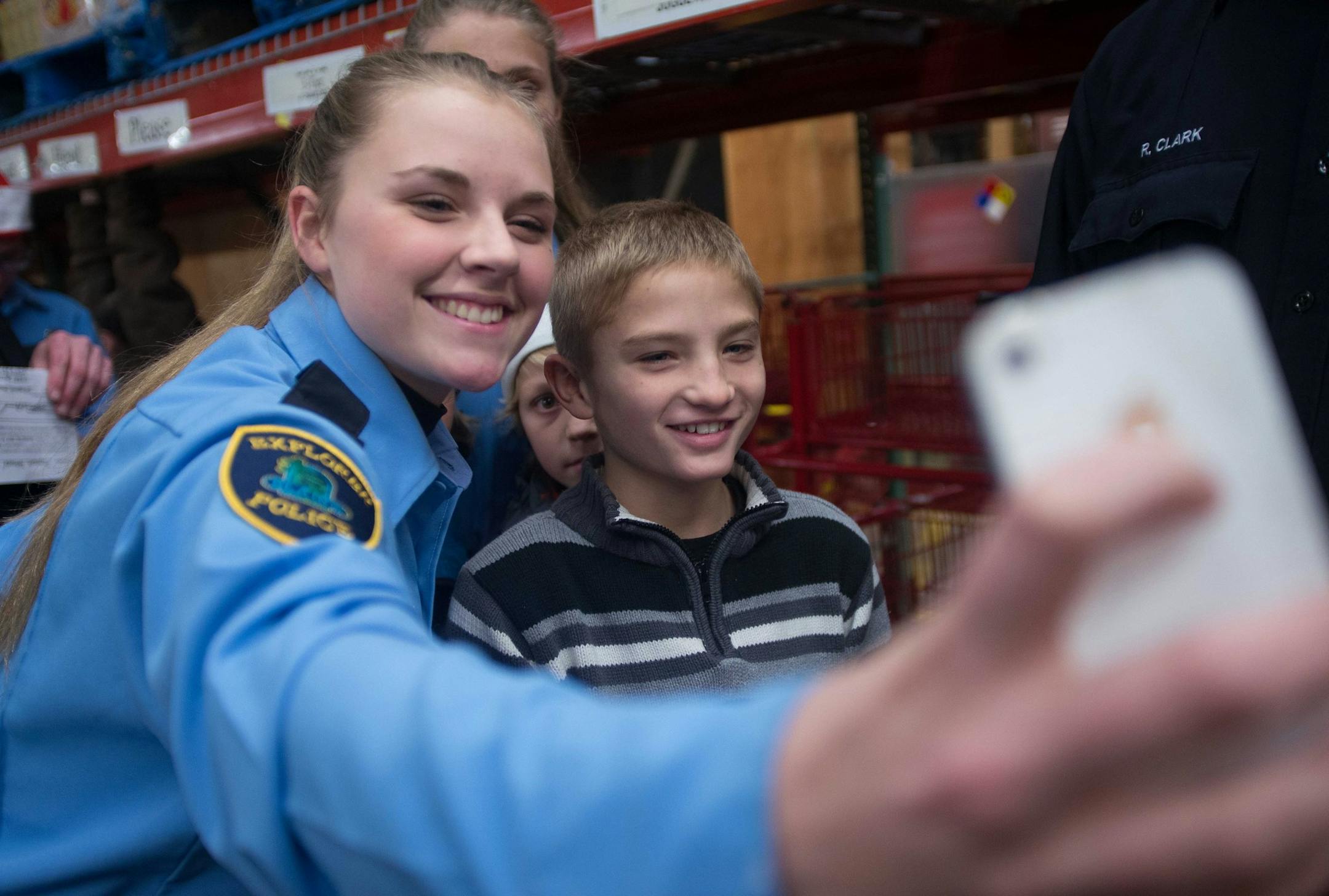 Blaine police explorer Jennah Justen (cq) takes a selfie with 10-year-old Logan James at the start of the Heroes and Helpers event Tuesday night. ] AARON LAVINSKY • aaron.lavinsky@startribune.com Anoka County cops and firefighters conduct their annual Heroes and Helpers event Tuesday, Dec. 2, 2014 at Target in Blaine. 48 children were given $100 gift cards to spend on themselves and their families while being escorted around target by first responders.