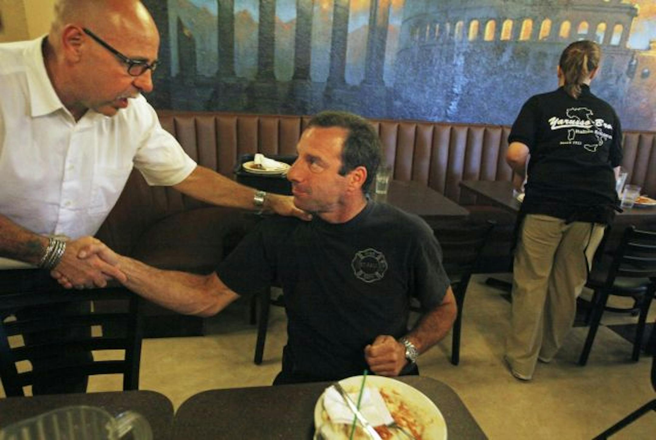 Owner Mike Yarusso thanked firefighter John D'Amato at an appreciation dinner for police and fire department folks. ladder the night of the fire in February.