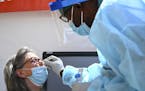 Finn Marube, a clinical scientist with North Memorial, administered a COVID-19 test to Sandra Lynn White, of Minneapolis, Wednesday afternoon behind t