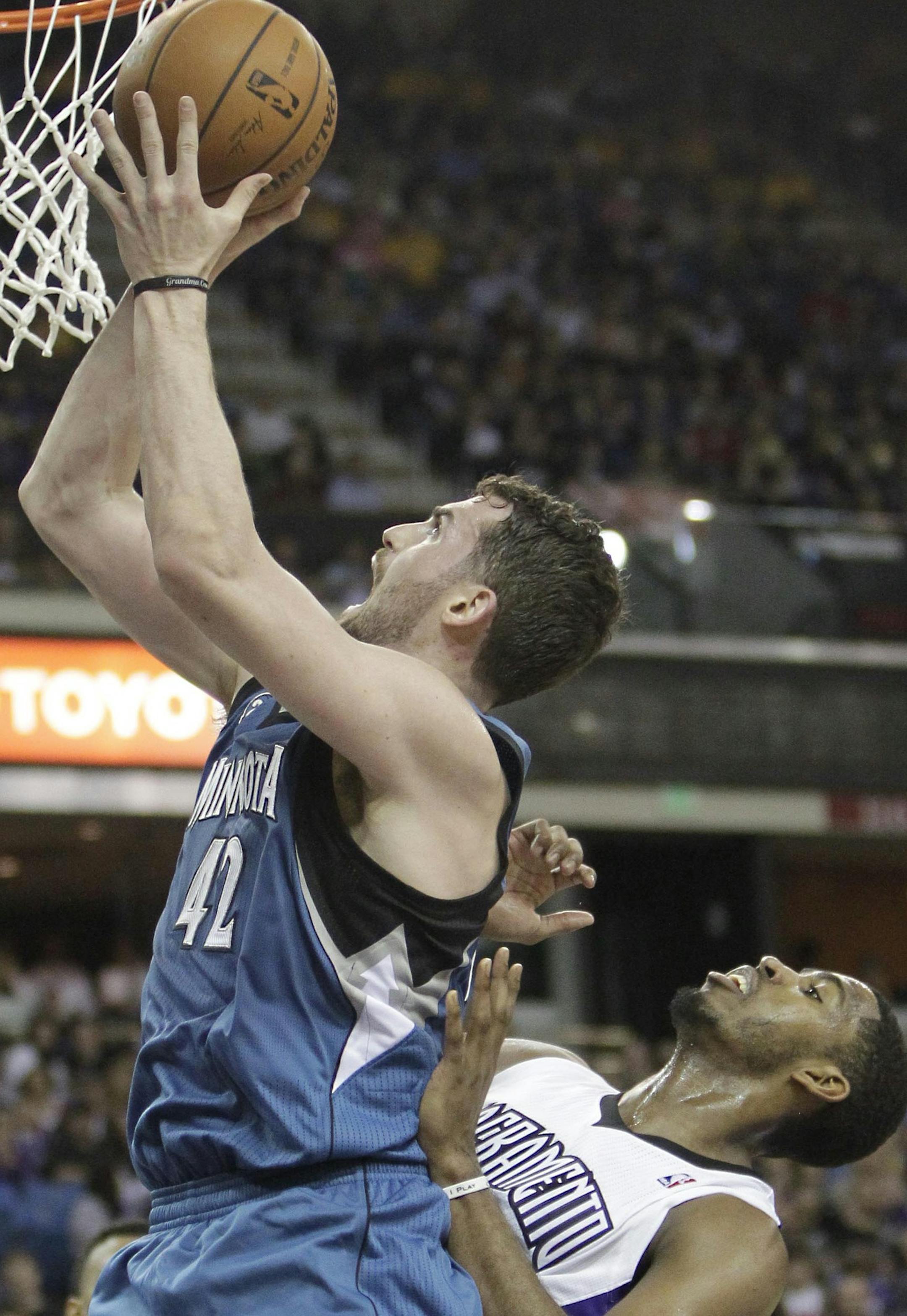 Minnesota Timberwolves forward Kevin Love, left, goes to the basket against Sacramento Kings forward Jason Thompson during the first quarter of an NBA basketball game in Sacramento, Calif., Saturday, March 1, 2014. (AP Photo/Rich Pedroncelli)