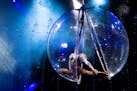 A performer with Cirque Italia's "Water Circus" performs in an aerial orb.