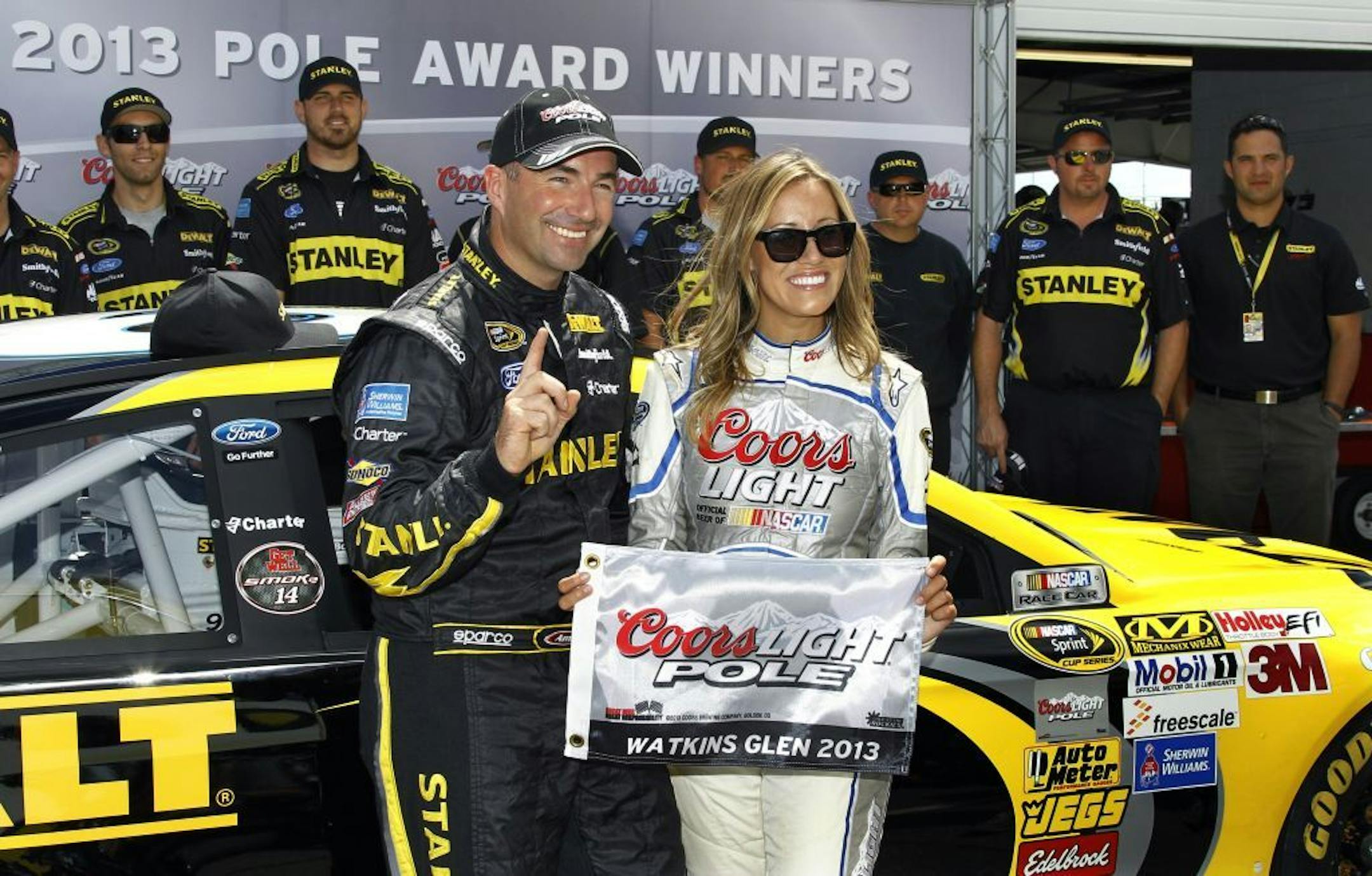Marcos Ambrose celebrates in the pits after qualifying on the pole for Sunday's NASCAR Sprint Cup Series auto race, Saturday Aug. 10, 2013, in Watkins Glen, N.Y. Ambrose took the pole with 128.241 miles per hour.