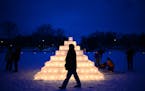 Brian Hackbarth, of Lake of the Isles, walked past an illuminated ice pyramid on Lake of the Isles during the Luminary Loppet Saturday night. ] (AARON