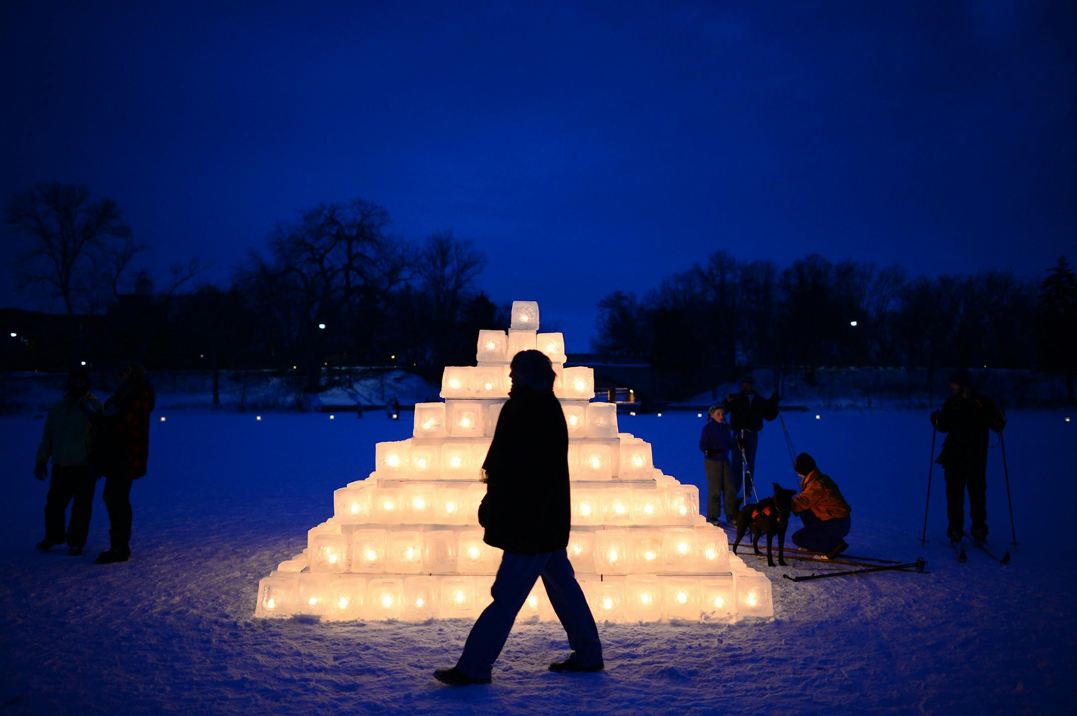 Brian Hackbarth, of Lake of the Isles, walked past an illuminated ice pyramid on Lake of the Isles during the Luminary Loppet Saturday night. ] (AARON LAVINSKY/STAR TRIBUNE) aaron.lavinsky@startribune.com The Luminary Loppet night of the City of Lakes Loppet Ski Festival was held Saturday, Feb. 6, 2016 at Lake of the Isles in Minneapolis, Minn.
