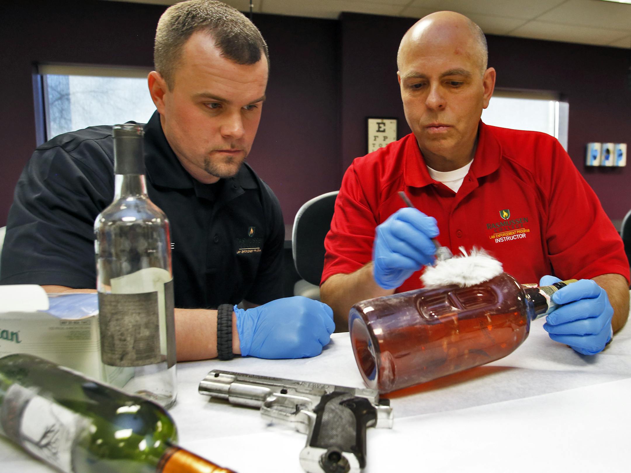 Rasmussen College in Eagan has opened a new police training facility with a number of scenario training rooms that depict situations police may find themselves in public encounters. Law enforcement student Dave Eichman, left, watches as instructor Bentley Jackson uses a duster to teach the skills of fingerprinting a piece of crime evidence. (MARLIN LEVISON/STARTRIBUNE(mlevison@startribune.com)