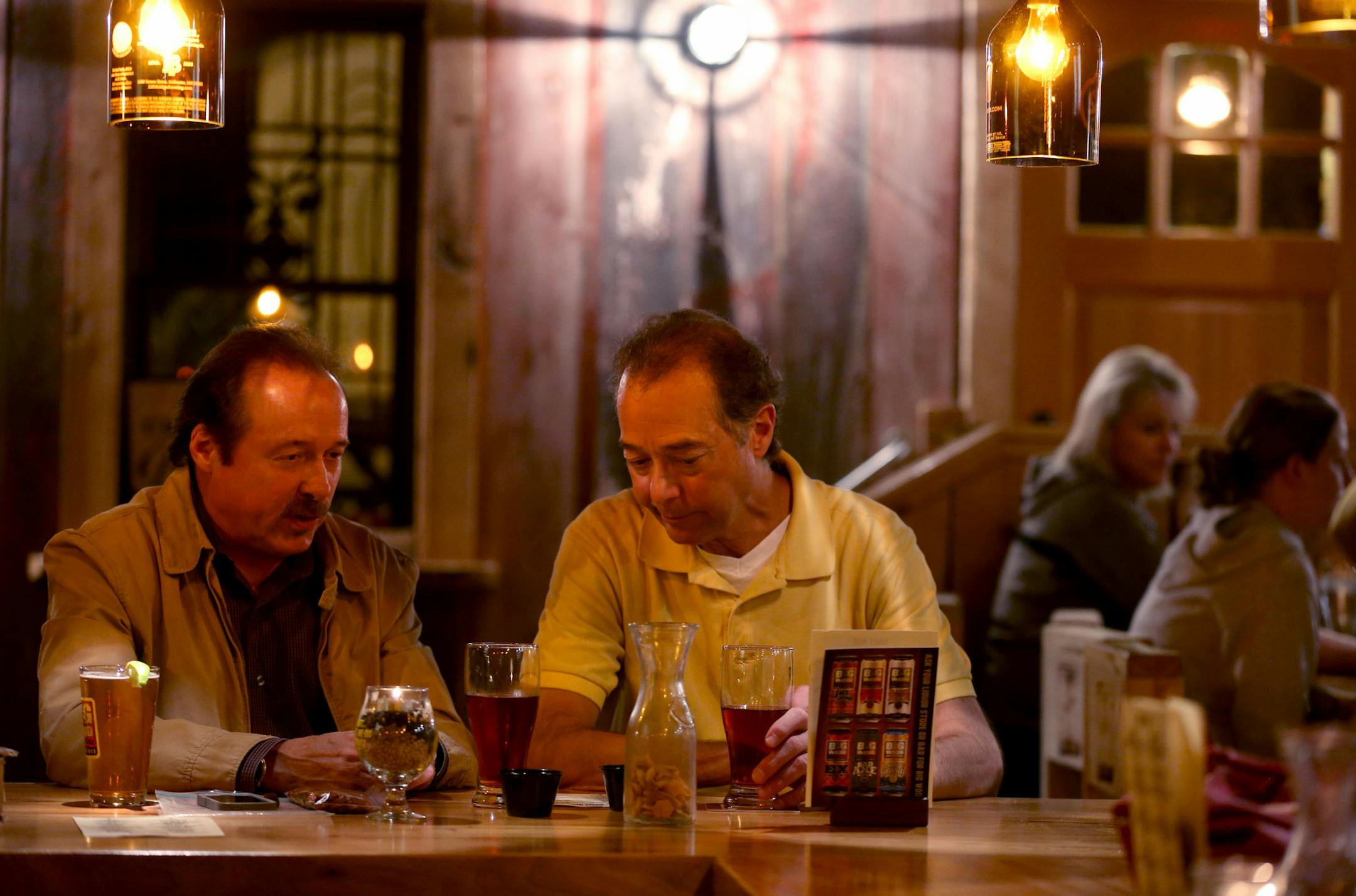 Jerry Helget, left, and Steve Marier shared stories as they drank beer and ate spicy almonds Marier made. ] (KYNDELL HARKNESS/STAR TRIBUNE) kyndell.harkness@startribune.com At Big Wood Brewery in White Bear Lake Min., Saturday, October 18, 2014.