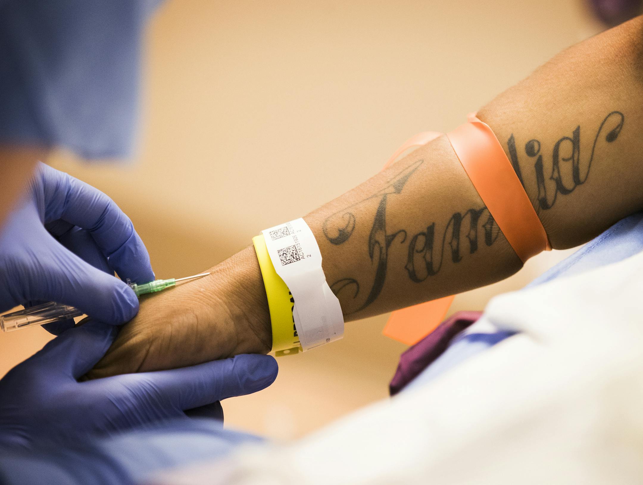 A doctor administers an IV in Carlo's arm before surgery. A tattoo that says "Familia" is seen on his forearm. ] LEILA NAVIDI ï leila.navidi@startribune.com BACKGROUND INFORMATION: Jeremy Villafan Priego donates a kidney to his brother Carlos Villafan Priego, who has been on dialysis for years, in a surgery performed at University of Minnesota Medical Center in Minneapolis on Thursday, September 14, 2017. Both brothers are DACA recipients. Carlos has his health coverage through his job as a