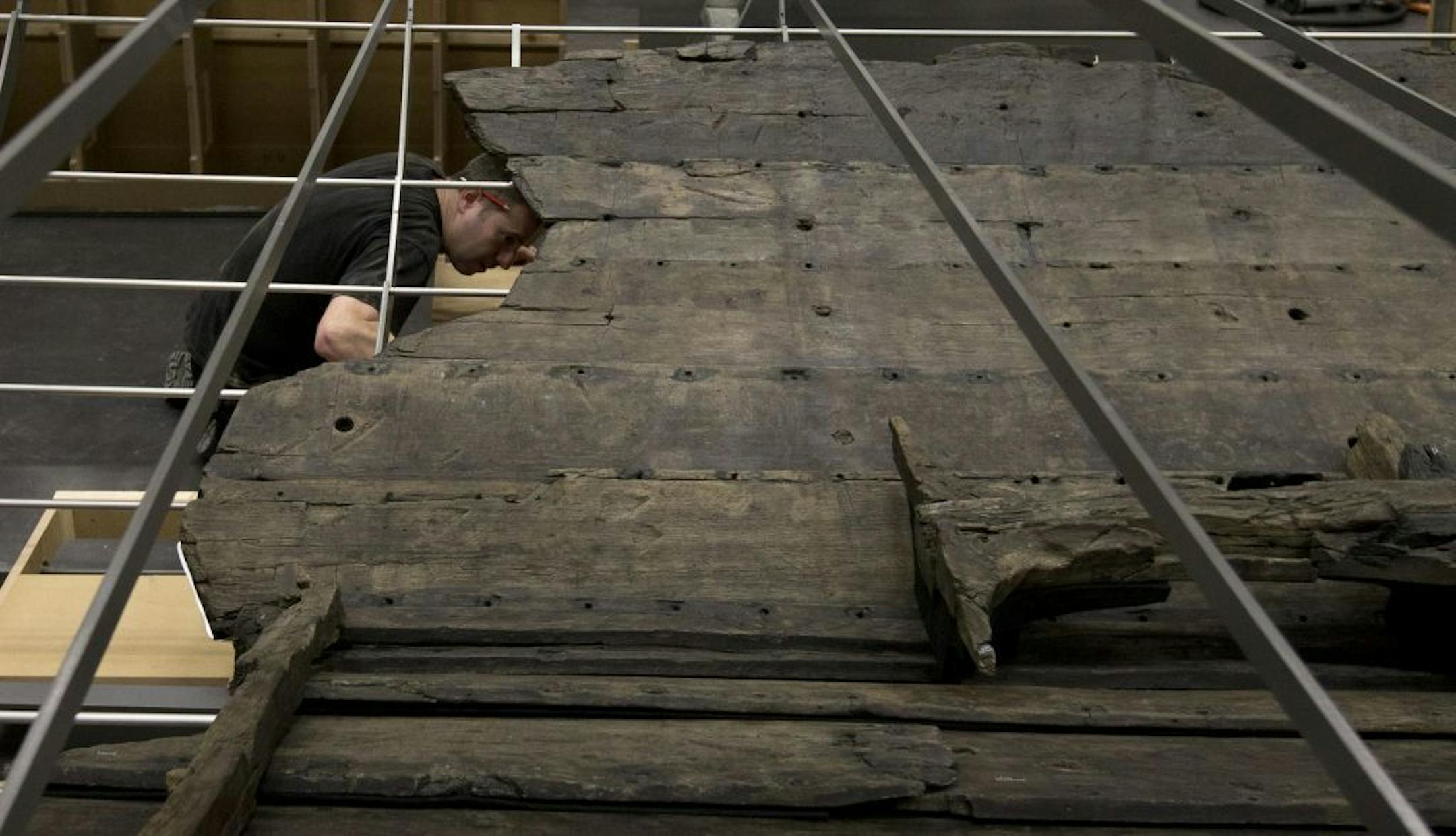 A conservator helps with the final assembly of The Viking ship known as Roskilde 6.