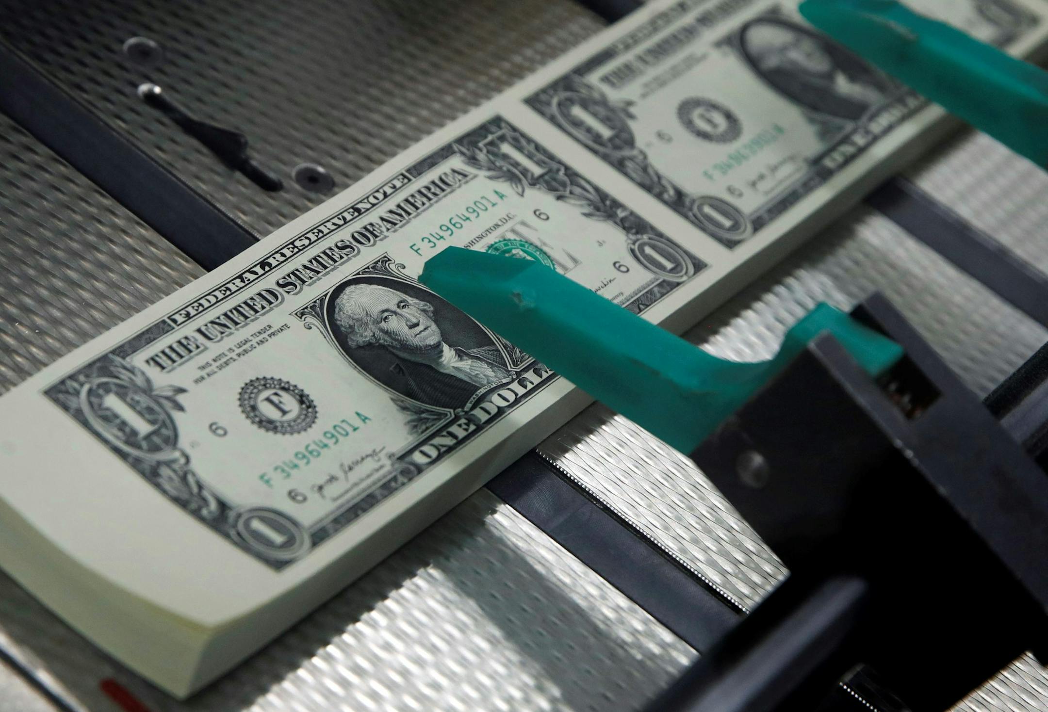 New $1 bills with the signatures of U.S. Treasurer Jovita Carranza and Treasury Secretary Steven Mnuchin are cut and stacked, Wednesday, Nov. 15, 2017, at the Bureau of Engraving and Printing in Washington. The Mnuchin-Carranza notes, which are a new series of 2017, 50-subject $1 notes, will be sent to the Federal Reserve to issue into circulation. (AP Photo/Jacquelyn Martin) ORG XMIT: DCJM109