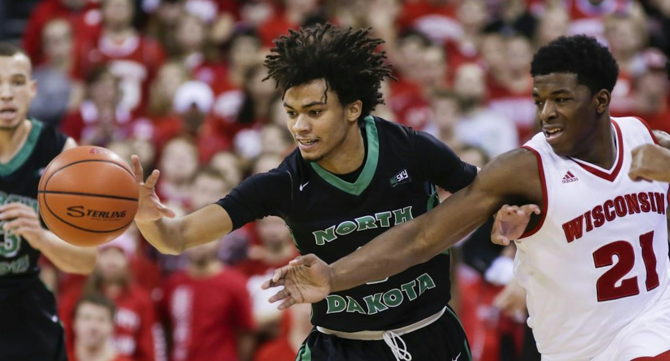 North Dakota's Geno Crandall, left, and Wisconsin's Khalil Iverson (21) vie for a loose ball during the first half of an NCAA college basketball game, Tuesday, Nov. 17, 2015, in Madison, Wis.