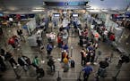 Travelers waited in line to pass through a TSA security checkpoint at Minneapolis-St. Paul International Airport.